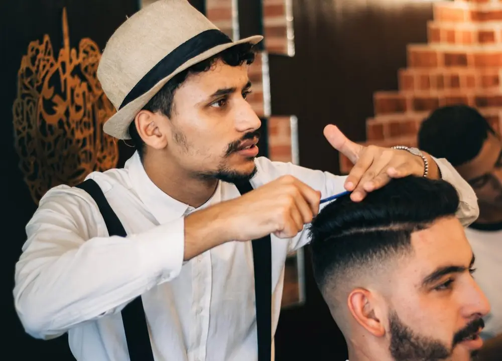 Interior da barbearia Meking, com cadeiras de barbeiro de couro