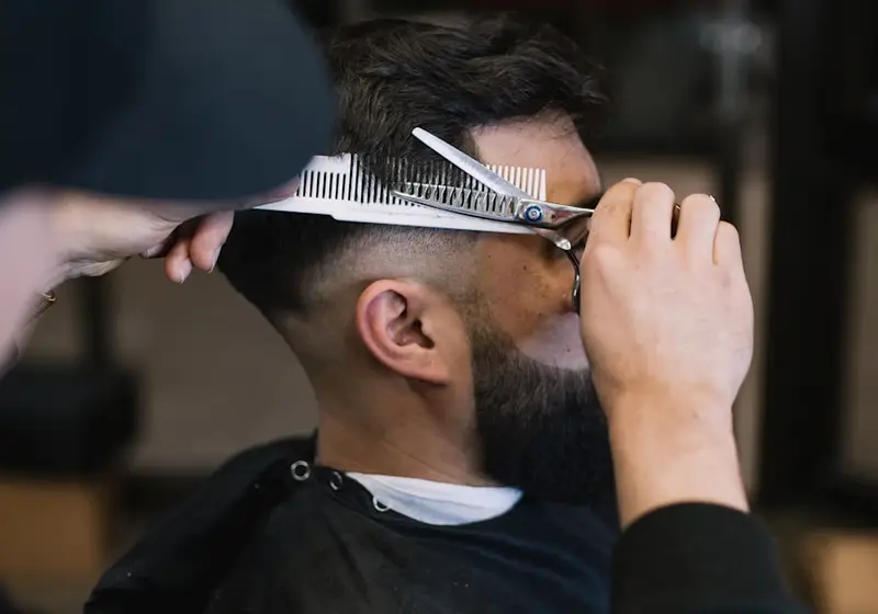 Barbeiro a executar um corte de cabelo